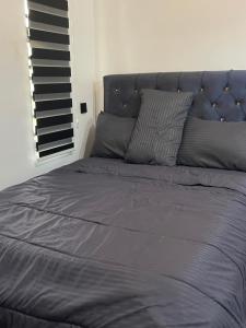 a bed with a blue blanket and pillows at Extravaganza Stay in Lagos +14 photos