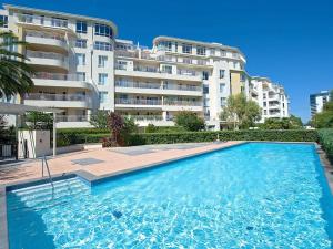 a large swimming pool in front of a building at StayCentral - The Park Port Melbourne in Melbourne