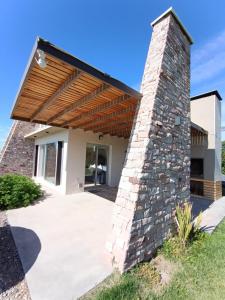 a house with a stone pillar and a wooden roof at De Alma Tinta - Petit Chalet in San Rafael