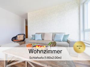 a living room with a couch and a table at Ostsee-Traumferienwohnungen Bel Vital mit Meerblick, Balkon und Sauna in Binz +37 photos