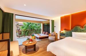 ein Hotelzimmer mit Bett und Balkon in der Unterkunft Burasari Phuket Resort & Spa in Patong Beach