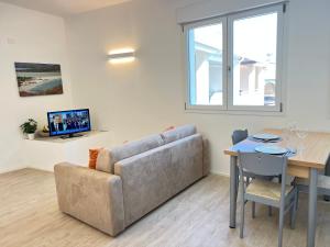 a living room with a couch and a table at Moderno appartamento dí Beniamino Murgioni a Villasimius in Villasimius