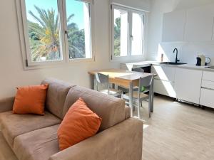 a living room with a couch and a table and a kitchen at Moderno appartamento dí Beniamino Murgioni a Villasimius in Villasimius