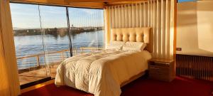 a bedroom with a bed and a large window at Los uros Jakana Lodge in Puno