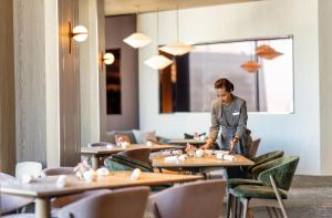 a woman standing at a table in a restaurant at ANA InterContinental Tokyo by IHG in Tokyo