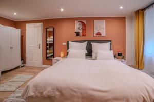 Blue Chili 35 - Apartment in Treptow في برلين: سرير كبير في غرفة النوم بجدران برتقالية