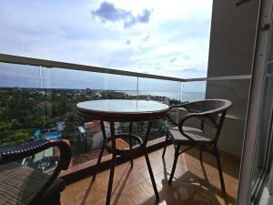 a table and two chairs on a balcony with a view at Sea view - Luxury Apartments by Tyronne in Negombo
