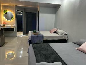 a room with two beds and a table with a mirror at Residencia Esmeralda in Agua Buena +48 photos