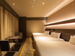 a hotel room with two beds and a desk at Hotel Keihan Kyoto Hachijoguchi in Kyoto +30 photos