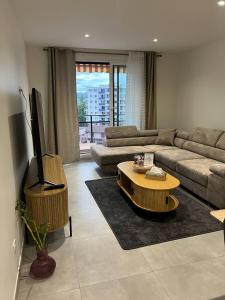 a living room with a couch and a tv and a table at Annecy Naila's apartement in Annecy