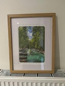 a framed picture of a swimming pool in a room at Annecy Naila's apartement in Annecy