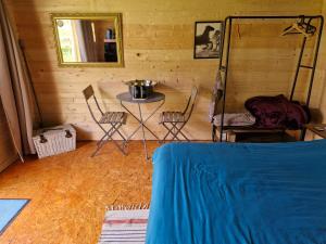 a room with a table and chairs and a mirror at La cabane des lucioles in Saint-Julien-Boutières