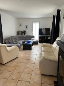 a living room with a couch and chairs and a tv at Villa Giens - Plage à pied -9 couchages in Hyères