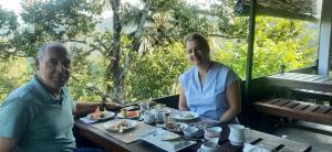 a man and a woman sitting at a table with food at Villa 95 Rangala in Kandy