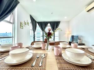 a dining room with a table with plates and utensils at CozyHome 1-10pax Sunway Nexis link IOI mall & MRT in Petaling Jaya