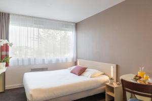 מיטה או מיטות בחדר ב-Appart'City Classic La Rochelle Centre