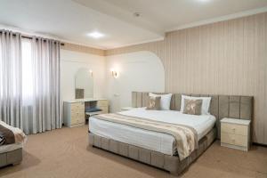 une chambre d'hôtel avec un lit et un bureau dans l'établissement Meros Boutique Hotel, à Samarcande 172 autres photos