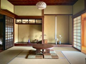 een kamer met een tafel in het midden van een kamer bij HANARE紡舎Tsumugiya in Ogawa +42 foto's