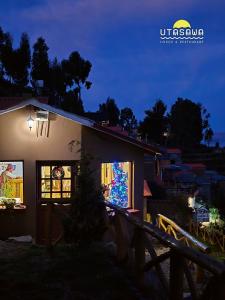 een kerstboom in een raam van een huis 's nachts bij Utasawa in Comunidad Yumani