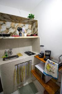 a kitchen with a sink and a stove in it at Flat inteiro 100m 1 Praia -Morro de Sao Paulo Bahia- mare mansa c in Cayru