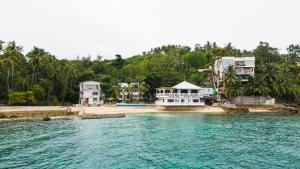 un gruppo di case su una spiaggia vicino all'acqua di SeTu Divespot & Resort a Boljoon