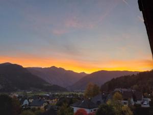 a sunset over a town with mountains in the background at Gruber Alexandra, Appartement mit Lungaucard in Sankt Michael im Lungau