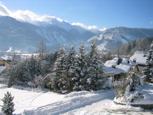a house covered in snow with trees and mountains at Gruber Alexandra in Sankt Michael im Lungau