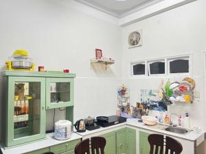 a kitchen with green cabinets and a sink at Nhà Bi'x in Da Lat