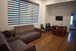 a living room with a couch and a table with chairs at Olivet Homestay in Vagamon