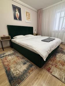 a bedroom with a large bed in a room with rugs at Studio Central in Onești