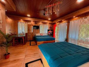 a bedroom with two beds and a table in it at Kanav Living Wooden Villa in Kanthalloor in Kanthalloor