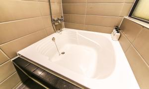 a bath tub in a bathroom with a sink at Chuncheon Urbane Hotel in Chuncheon