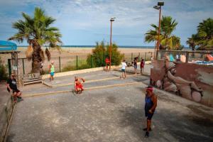 a group of people walking on a street near the beach at Mobile home in Sérignan