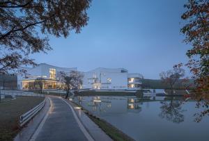 een gebouw naast een waterlichaam bij Xinchi Sakura Valley Resort in Shaoxing