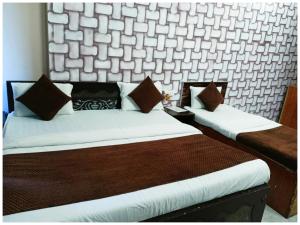 Postel nebo postele na pokoji v ubytování A PREMIUM HOTEL N A N D # P A L A C E - Near Sri Krishna Janambhoomi - Mathura Railway Juction - Parking and Wifi Facilities - Air Conditioning Luxury Room - A Top Rated Four Star Hotel