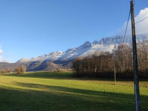 a view of a field with a mountain in the background at La chambre Nature chez les garçons in Saint-Paul-sur-Yenne