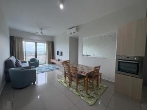 a kitchen and living room with a table and chairs at The Makcik's Homestay at Almyra Residence in Kajang