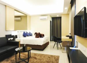 ein Hotelzimmer mit einem Bett und einer Couch in der Unterkunft The ECON at Genting Highlands in Genting Highlands
