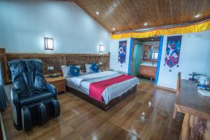 a bedroom with a king sized bed and a chair at Lugu Lake Motorcycle Travel Home in Zuosuo