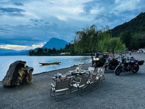 a table and chairs and motorcycles parked on a beach at Lugu Lake Motorcycle Travel Home in Zuosuo