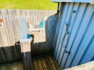 a wooden fence with a shower and a sink at Close to the Beach, Large Garden with 2 Patios & BBQ in Falkenberg
