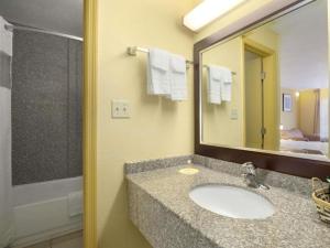 a bathroom with a sink and a mirror at Days Inn by Wyndham Brunswick/St. Simons Area in Glynn Heights +5 photos