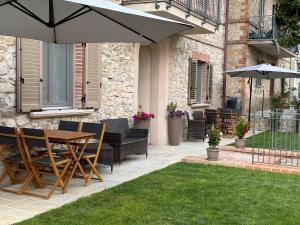 a patio with a table and chairs and an umbrella at Via Roma 34 in Castiglione del Lago
