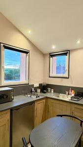 a kitchen with two windows and a sink and a table at Studio Prenois in Prenois +2 photos