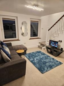 a living room with a couch and a table and stairs at Riveredge Apartment in Pedlars Cross Roads