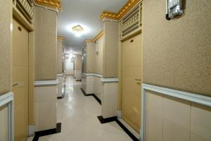 einen Flur eines Gebäudes mit Türen und Fliesen in der Unterkunft Dancenter Padang City Center Near Gunung Padang Formerly Hotel Fitriaendika in Padang