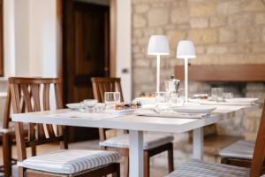a white table with chairs and plates and lamps at Le Fontanelle Country House in SantʼIppolito