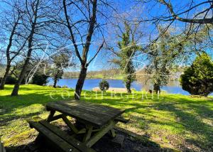 un tavolo da picnic sull'erba vicino a un lago di "Les Bonnes Ondes" aux gîtes de l'Etang Neuf by Kastell Breizh a Saint-Connan