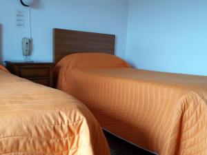 two beds in a room with a blue wall at Pensao Vista Bela in Miranda do Douro