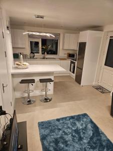 a kitchen with a counter and two bar stools at Riveredge Apartment in Pedlars Cross Roads